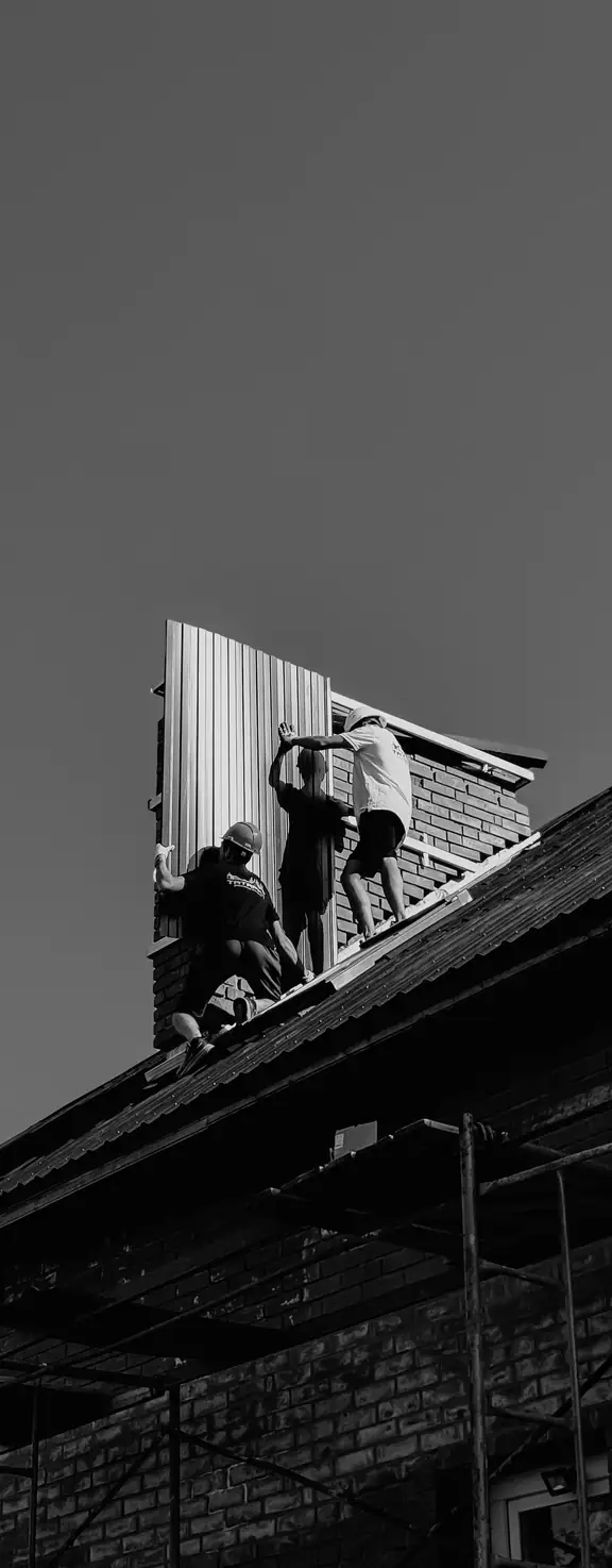 Crew fitting a metal roof panel
